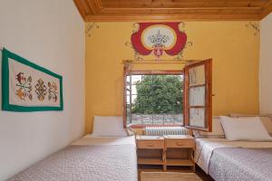 莫诺登德里Archontiko Rapti Stone Traditional House的带窗户的客房内的两张床
