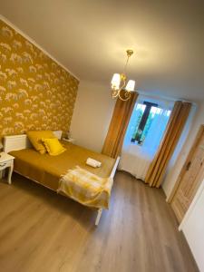 奥斯威辛Lu Residence - Unique Apartments的一间卧室配有一张带黄色毯子和窗户的床