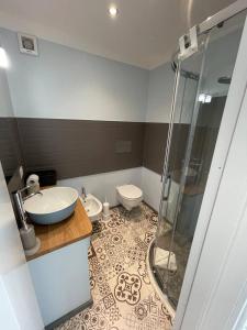奥尔比亚Gaias Rooms的带淋浴、盥洗盆和卫生间的浴室
