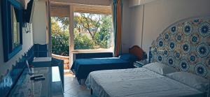 卡普里4季酒店的一间卧室设有两张床和窗户。