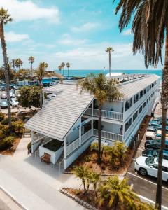 圣地亚哥Del Mar Beach Hotel的享有棕榈树和大海建筑的空中景致