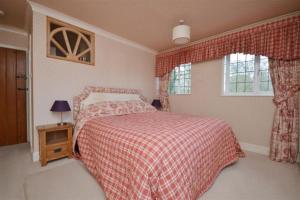 伯利Holmans NEW FOREST的一间卧室配有一张带红色毯子的床和窗户。