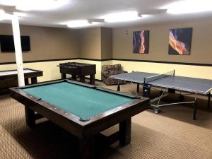 布赖恩峰King Bed Condo at Cedar Breaks Lodge的两个乒乓球桌,房间有两个桌子