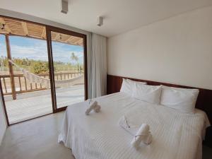 佩德拉斯港Casa Seriguela - Praia do Patacho - Rota Ecológica dos Milagres的卧室配有带白色床单的床铺和大窗户