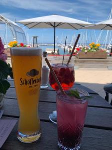 奥斯赛拜-屈隆斯博恩Ferienwohnung Yachthafenperle的木桌旁放着两杯饮料