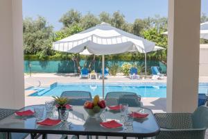 阿尔加卡Rafaella Beach Villa- Pvt Pool-Near Sea/Beach的游泳池旁带遮阳伞的桌子