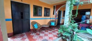帕纳哈切尔Hospedaje El Viajero的客房 - 带2把椅子和红色瓷砖地板