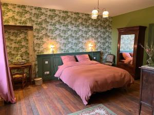 蒙蒂尼亚克Le Clos Chalmon Chambre d'hôte的一间卧室配有一张带粉红色棉被的床