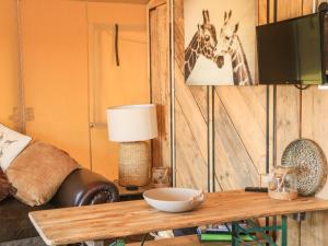托特尼斯Semira Tent Lodge的客厅配有桌子和墙上的两长颈鹿