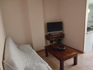 贝尼多姆Apartamentos Casa May II - Centro Benidorm的客厅配有沙发和桌子上的电视