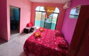 巴克里索莫雷诺港La Casa de Jeimy的粉红色的客房设有一张红色的桌子