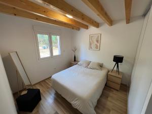拉卡诺La Casa de Lacanau的卧室配有白色的床和窗户。