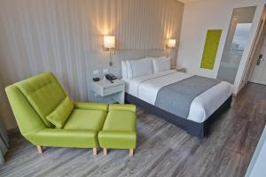 伊瓦格Sonesta Hotel Ibagué的配有一张床和一把椅子的酒店客房