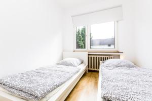 科隆科隆怀登佩奇公寓的白色客房的两张床,设有窗户