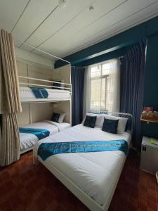 曼谷Acozyposhtel的蓝色墙壁客房的两张床
