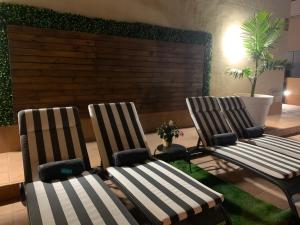 圣地亚哥港Villa View Candesol con Jacuzzi privado的客厅里摆放着两把椅子,里面种有植物