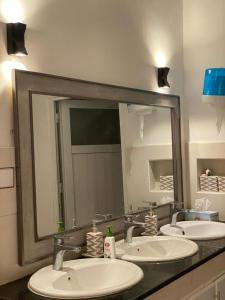 塞拉莱Almouj Chalet的一间带三个水槽和大镜子的浴室