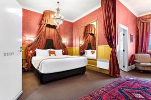 格雷敦白天鹅酒店的一间卧室设有一张带红色墙壁的大床