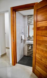 圣多明各Super Luxurious L6 Sky Blue Apartment的一间带水槽和木门的浴室