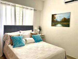 圣多明各Super Luxurious L6 Sky Blue Apartment的一间卧室配有一张带蓝色和白色枕头的床