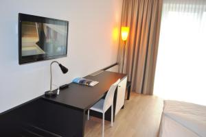 林茨城市酒店 的酒店客房设有一张桌子、一台电视和一张床