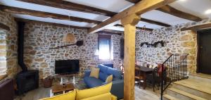 Miñera de LunaCasa Rural Carmen Luna的客厅设有蓝色的沙发和石墙