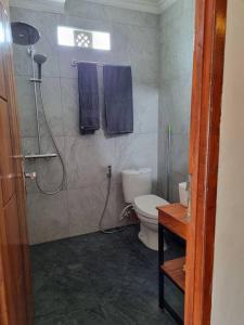 马塔兰Suci's Friendly Appartment的浴室设有卫生间和带蓝色毛巾的淋浴。