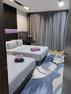 斯里巴加湾市Qing Yun Rest House Koprijaya, Brunei Darussalam的酒店客房配有两张带紫色枕头的床