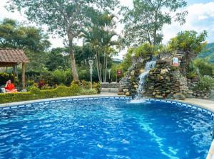 比尔卡班巴Hostería Paraíso的庭院内带瀑布的游泳池