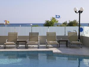 罗希姆诺克里提海滩酒店 的一组椅子坐在游泳池旁