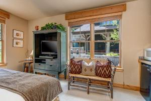 帕克城Lodges at Deer Valley - #2220的一间卧室设有一张床、一台电视和一个窗口。