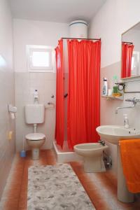 苏佩塔尔Apartments with a parking space Supetar, Brac - 6035的一间带红色淋浴帘和卫生间的浴室