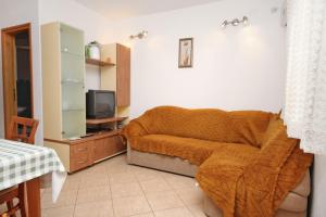 苏佩塔尔Apartments with a parking space Supetar, Brac - 6037的一间卧室配有一张带毯子的床和一台电视。