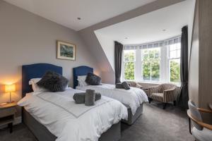 吉伦Caddyshacks Gullane, 4 bedroom, 4 bath, Golf, Beach的一间卧室设有两张床和窗户。