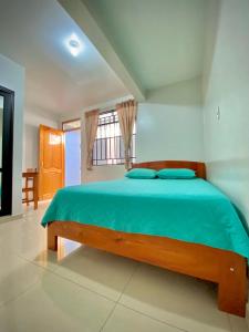 莫约班巴La Terraza Hospedaje的一间卧室配有一张带蓝色床单的床和一扇窗户。