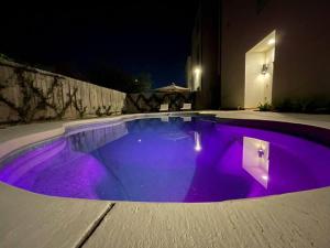 休斯顿Luxury Home w/ Private Saltwater Pool in Midtown的游泳池,晚上有紫色灯光