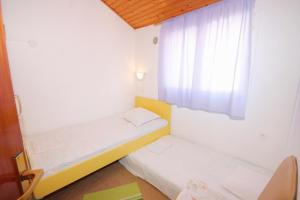 尼亚卢卡Apartments with a parking space Vela Luka, Korcula - 7551的小房间设有两张床和窗户
