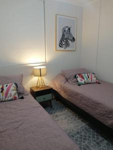 拉塞雷纳Departamento en La Serena的一间卧室配有两张床,一张斑马的照片