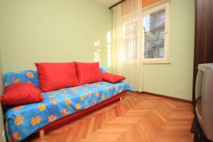 特罗吉尔Apartments by the sea Mastrinka, Ciovo - 7582的客厅里配有带红色枕头的蓝色沙发