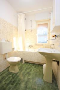 特罗吉尔Apartments by the sea Mastrinka, Ciovo - 7582的浴室配有卫生间、盥洗盆和浴缸。