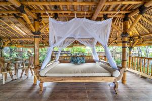 瑟克通Catappa Village Lombok的凉亭内的一张床位,配有蚊帐