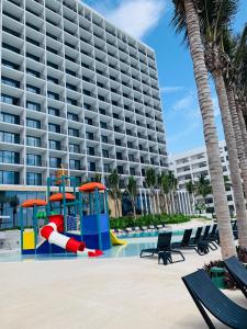 马萨特兰Viaggio Resort Mazatlán的酒店前方设有一座带游乐场的游泳池