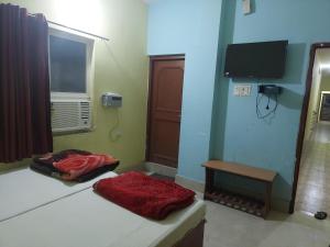 菩提伽耶拉玛旅馆的客房设有两张床、一个窗户和电视。