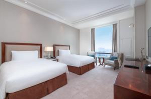 上海上海中庚聚龙酒店的酒店客房配有两张床和一张书桌