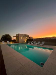 萨尔塔Tierras del Norte的一个带椅子的游泳池,享有日落美景