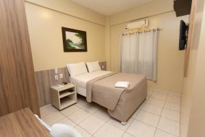 帕劳阿佩巴斯HOTEL EXECUTIVO的一间小卧室,配有一张床和一个卫生间