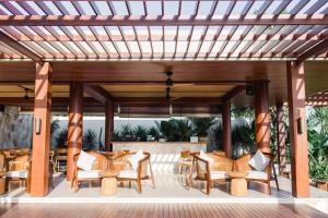 塔巴南Amarta Beach Retreat by Nakula的庭院内带桌椅的木制凉亭
