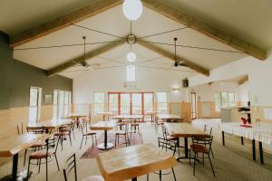 怀托摩洞穴Waitomo Village Chalets home of Kiwipaka的用餐室设有桌椅和窗户。