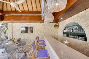 库塔Puspa Ayu Villas & Apartments的一间设有蓝色椅子的餐厅和一间酒吧