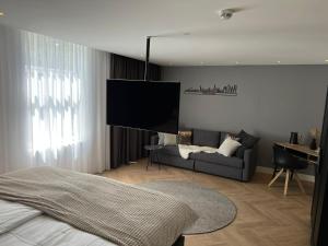 海牙Boutique Hotel Ravioli Brothers的一间卧室配有一张床、一张沙发和一台平面电视。